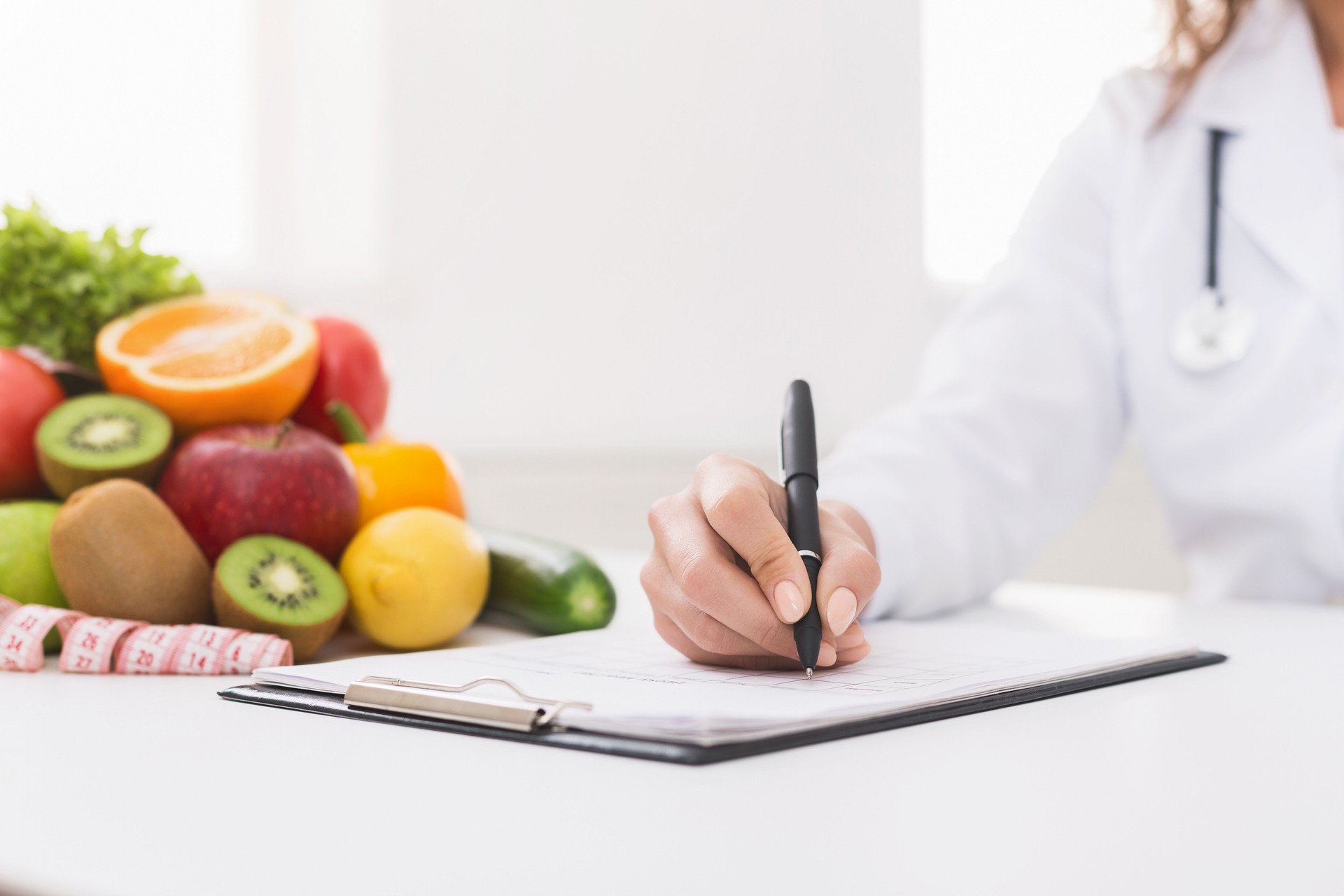 Medico nutrizionista che scrive su scartoffie in ufficio